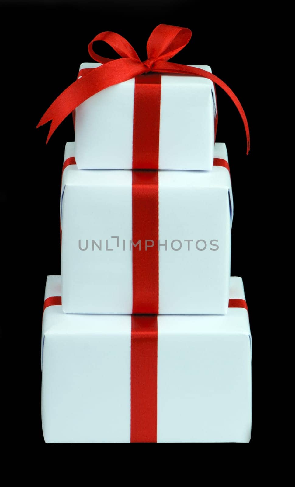 three white gift boxes with red ribbon isolated on black background