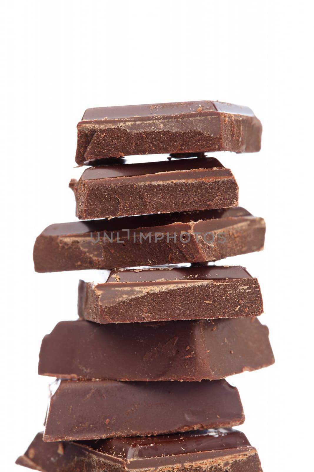 Blocks of chocolate isolated on white background. Shallow depth of field