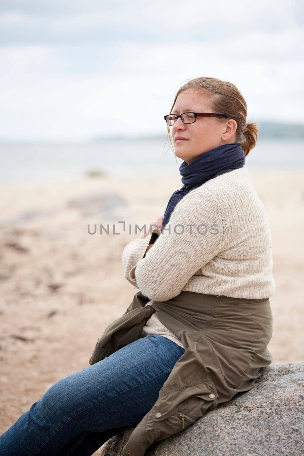 Woman sitting on a rock with a thoughtful expression
