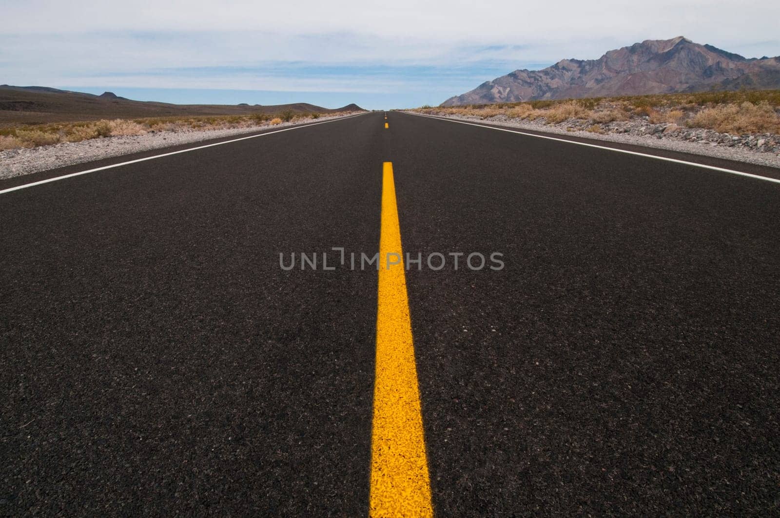 clean straight road through desert vanishing into distance