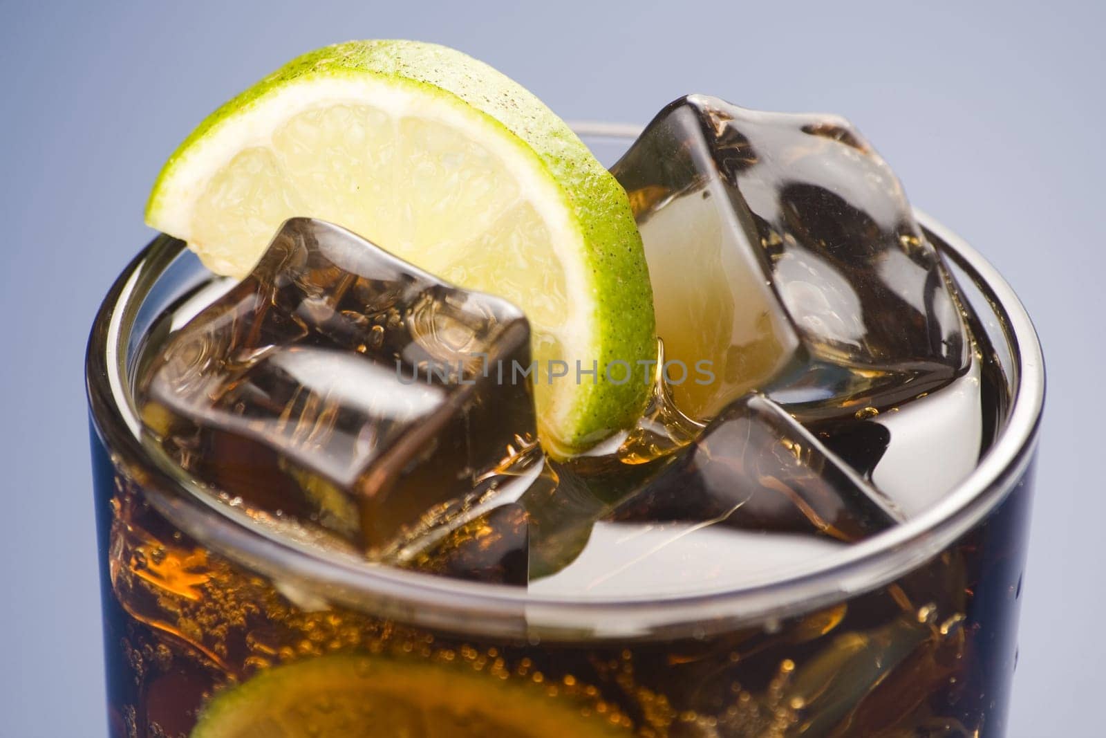 refreshing glass of cola with lemon and ice isolated