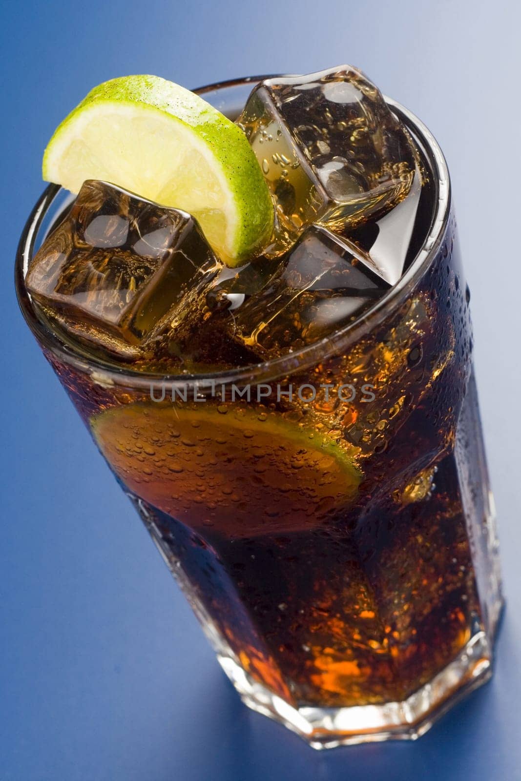 refreshing glass of cola with lemon and ice isolated