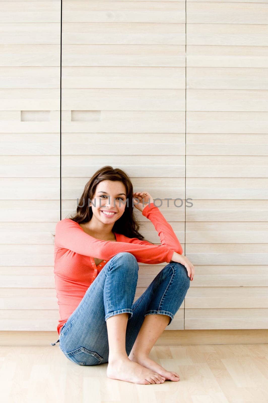 A young woman sitting on the floor at home
