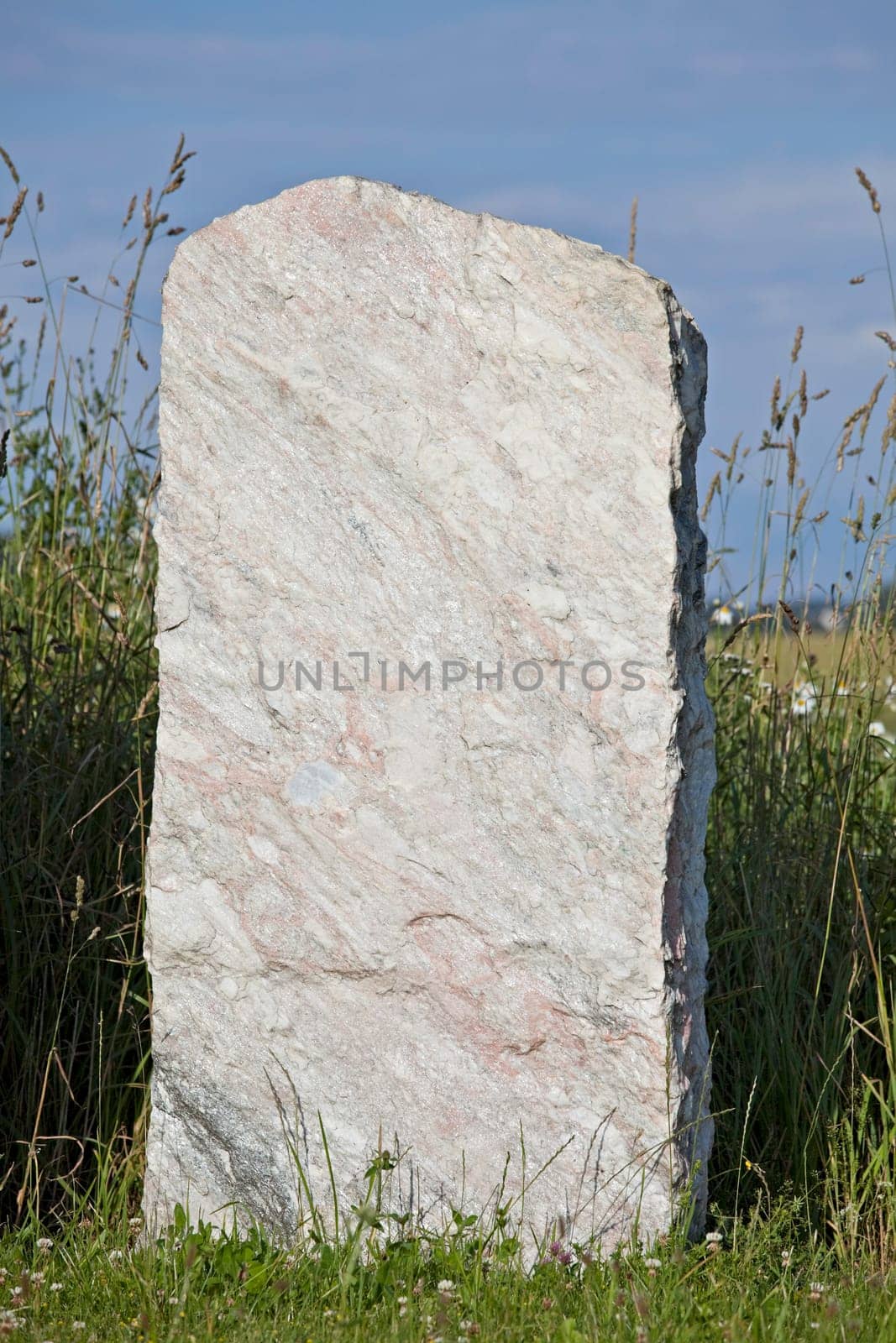 single empty granite gravestone on a grass meadow