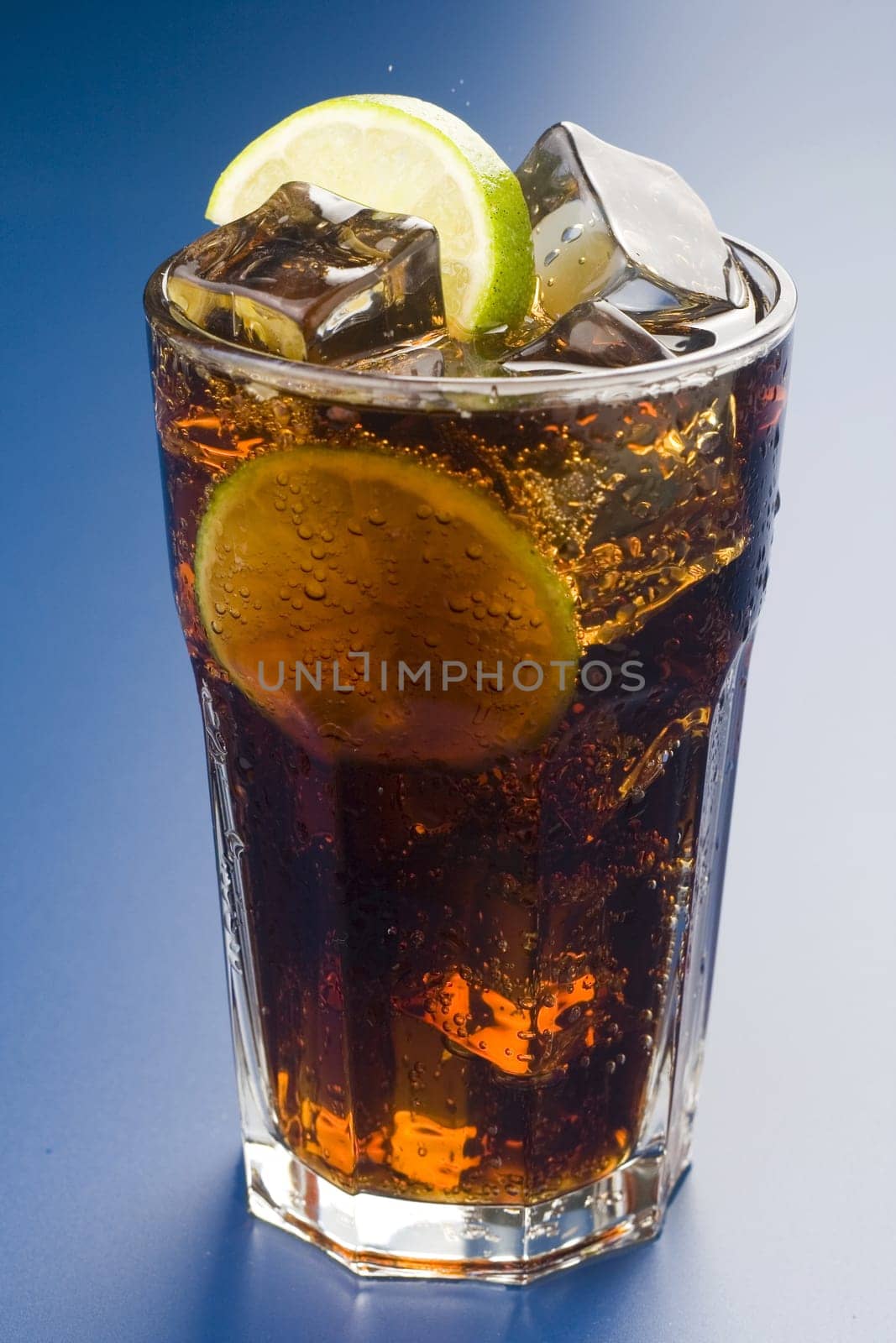 refreshing glass of cola with lemon and ice isolated