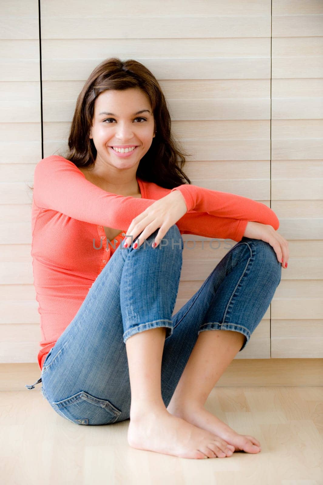 A young woman sitting on the floor at home