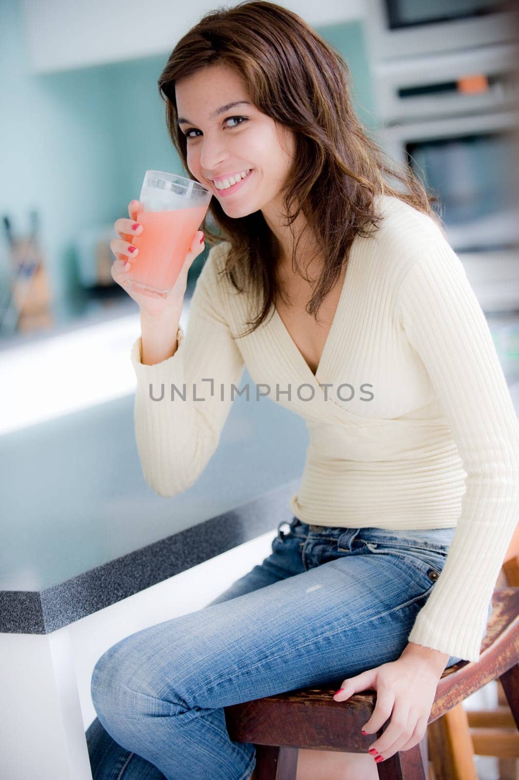 A young woman having juice in the kitchen