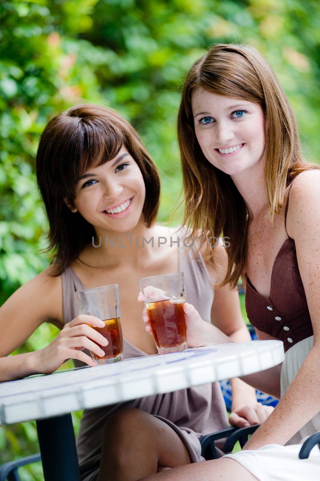 Two young attractive women having drinks together outside