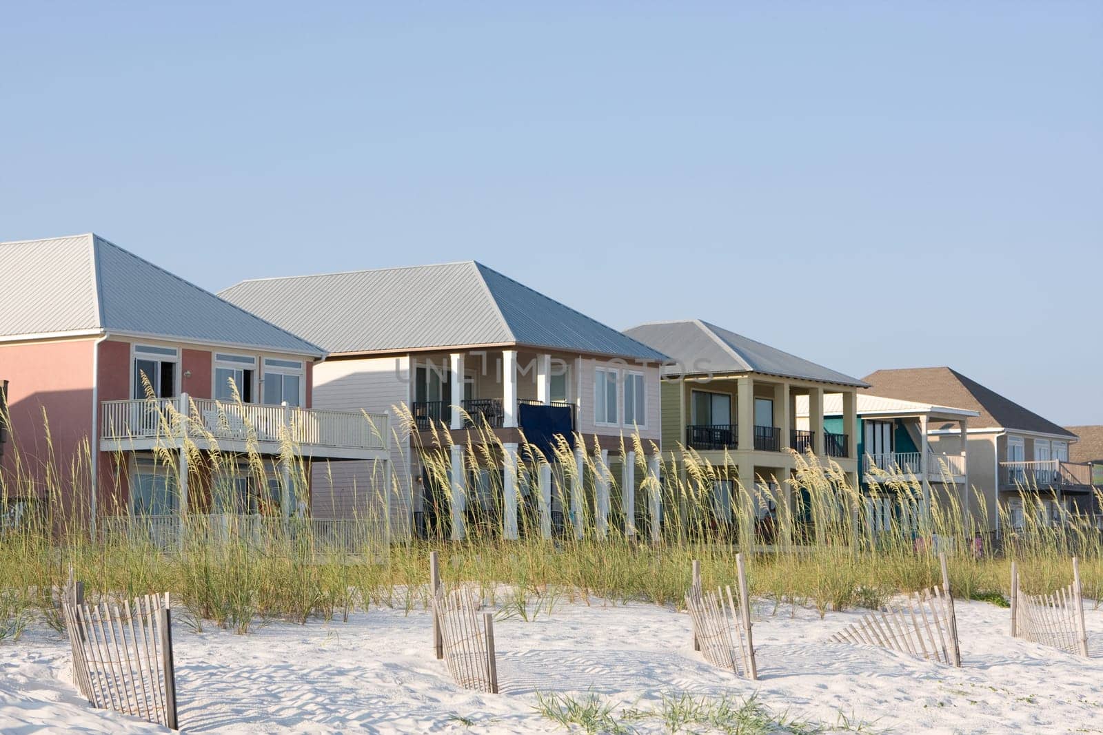 Vacation rental homes sit among the sea oats along the coastline.