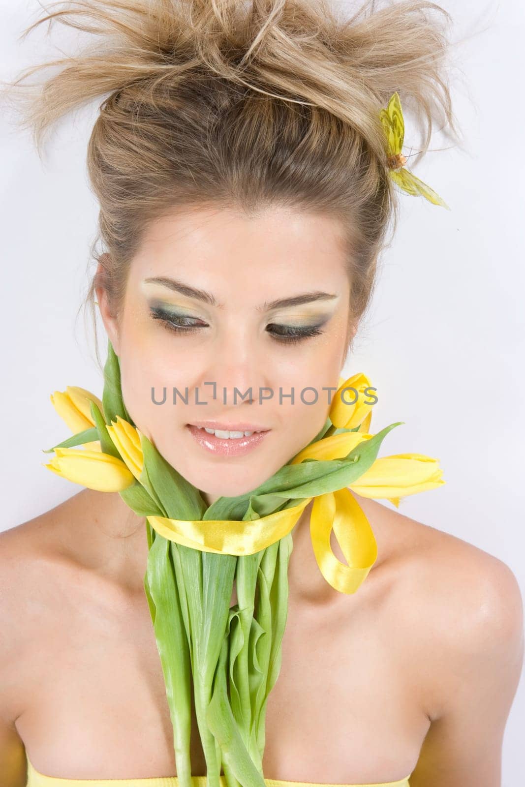 Close-up fresh funny blonde with beautiful make-up with tulips