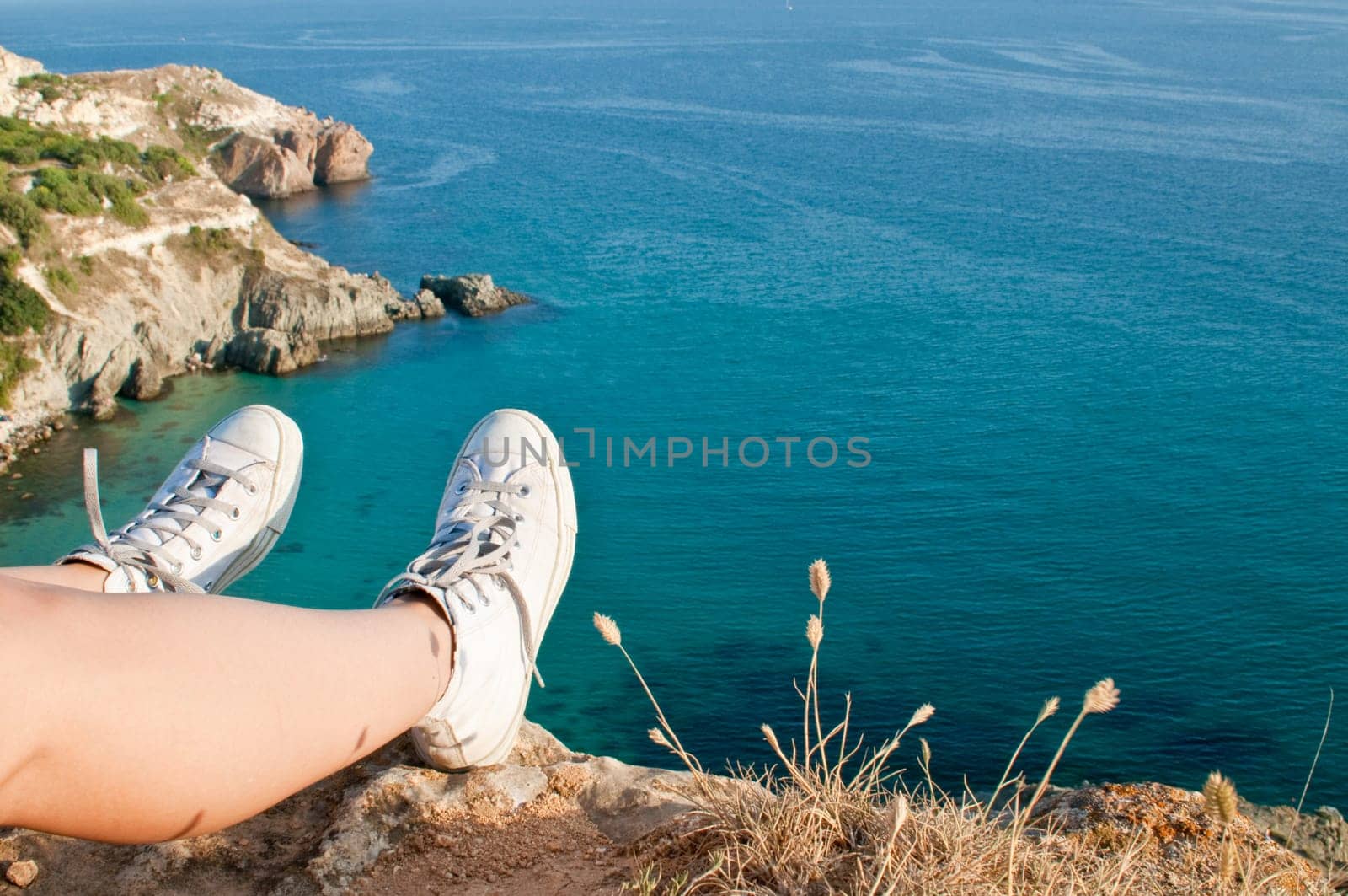 Tired feet of traveller on the top of the rock in Fiolent bay
