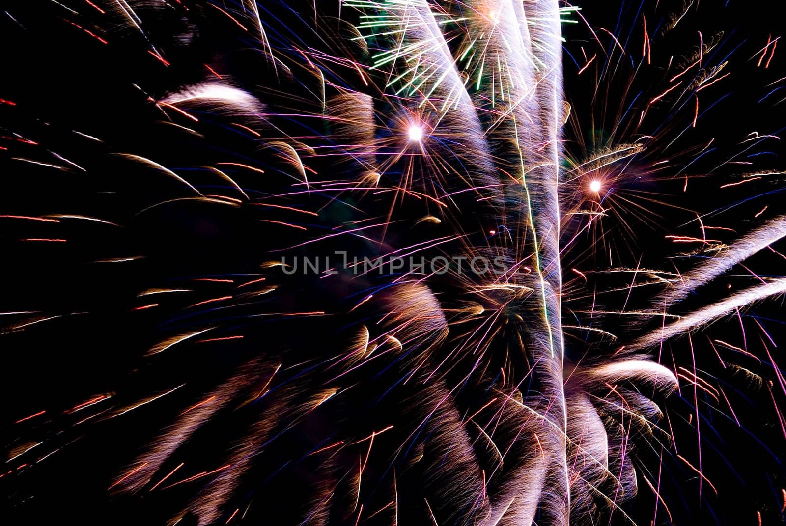 Fireworks exploding in the dark of the evening sky.