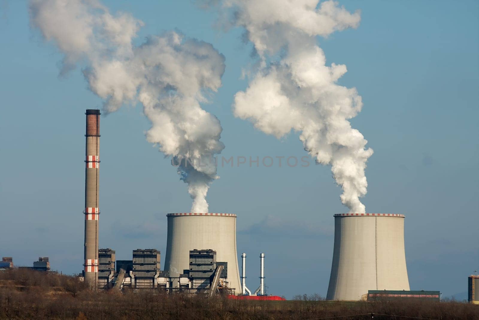 Smoke rises from a power plant to the sky