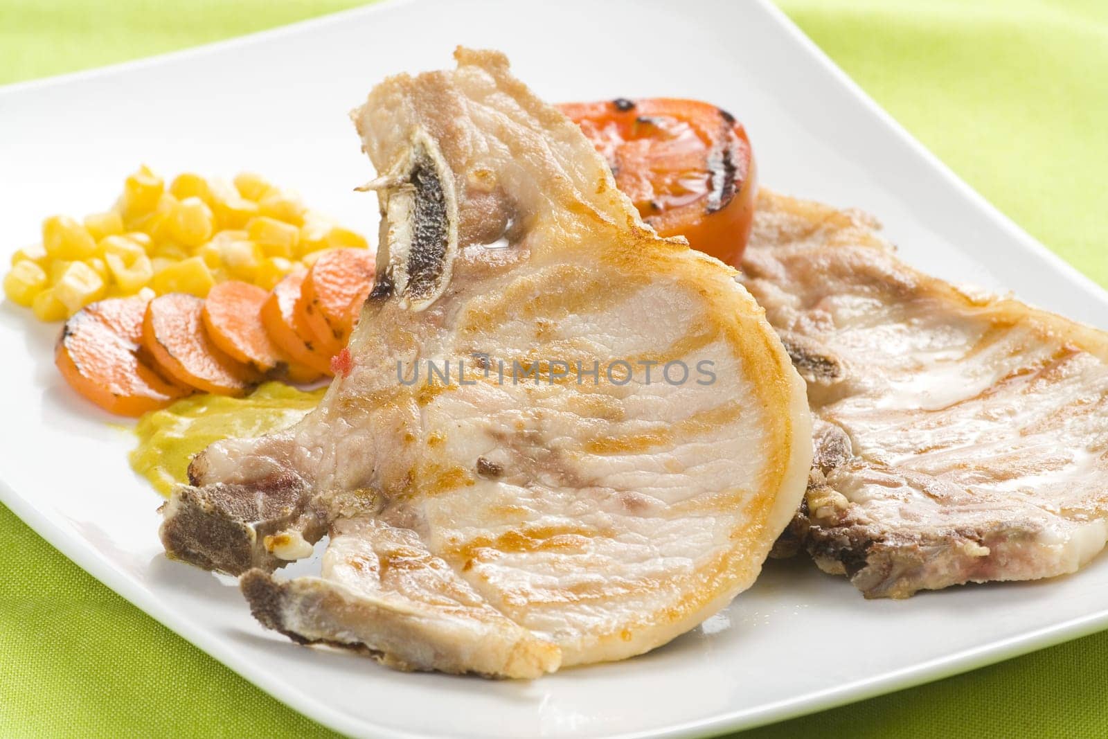 tasty pork chop with corn carrot tomato isolated