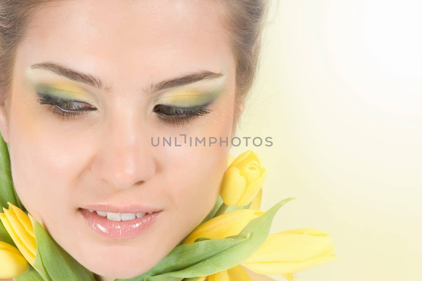 Close-up fresh blonde with beautiful make-up with tulips