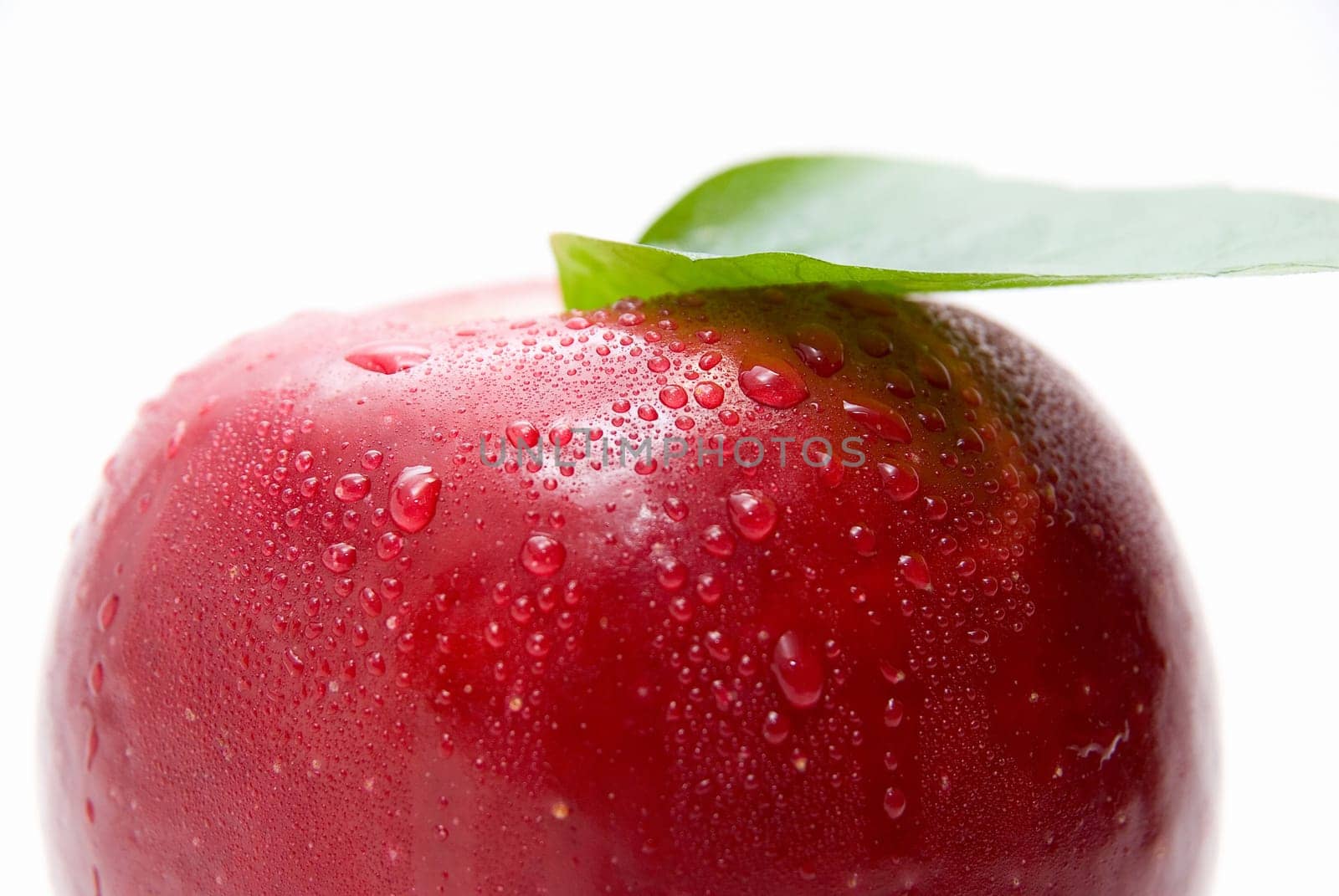 Close-up of ripe fresh red apple with leaf isolated on white