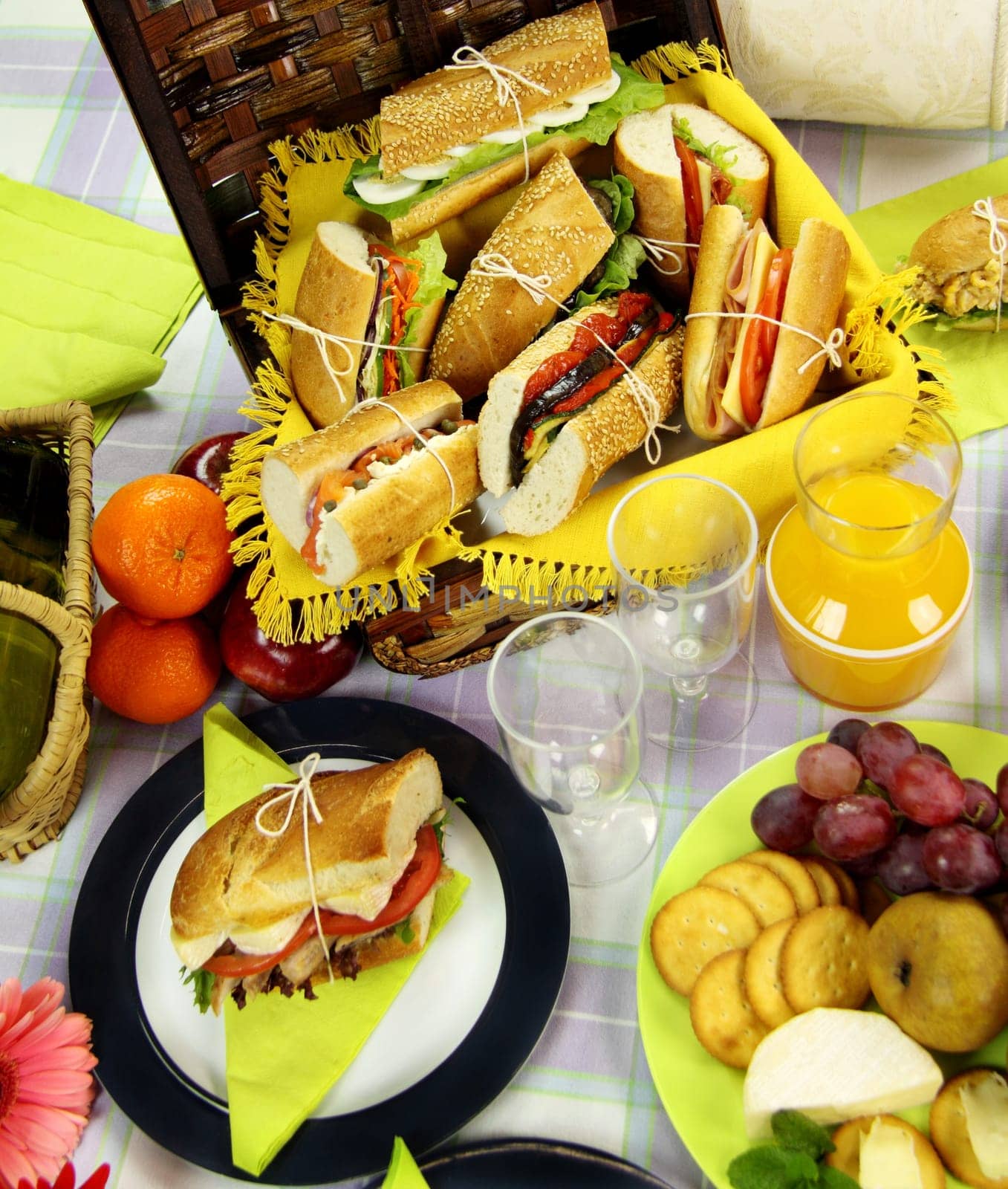 Selection of food for a picnic with a hamper, basket and fruit.