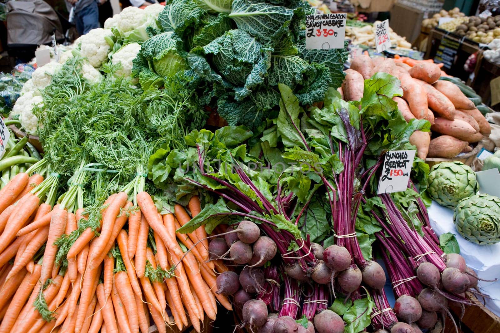 Carrots, Cauliflowers, Broad Beans, Cabbages, Beetroot, Artichokes, Sweet Potatoes, Priced up on a Market Stall