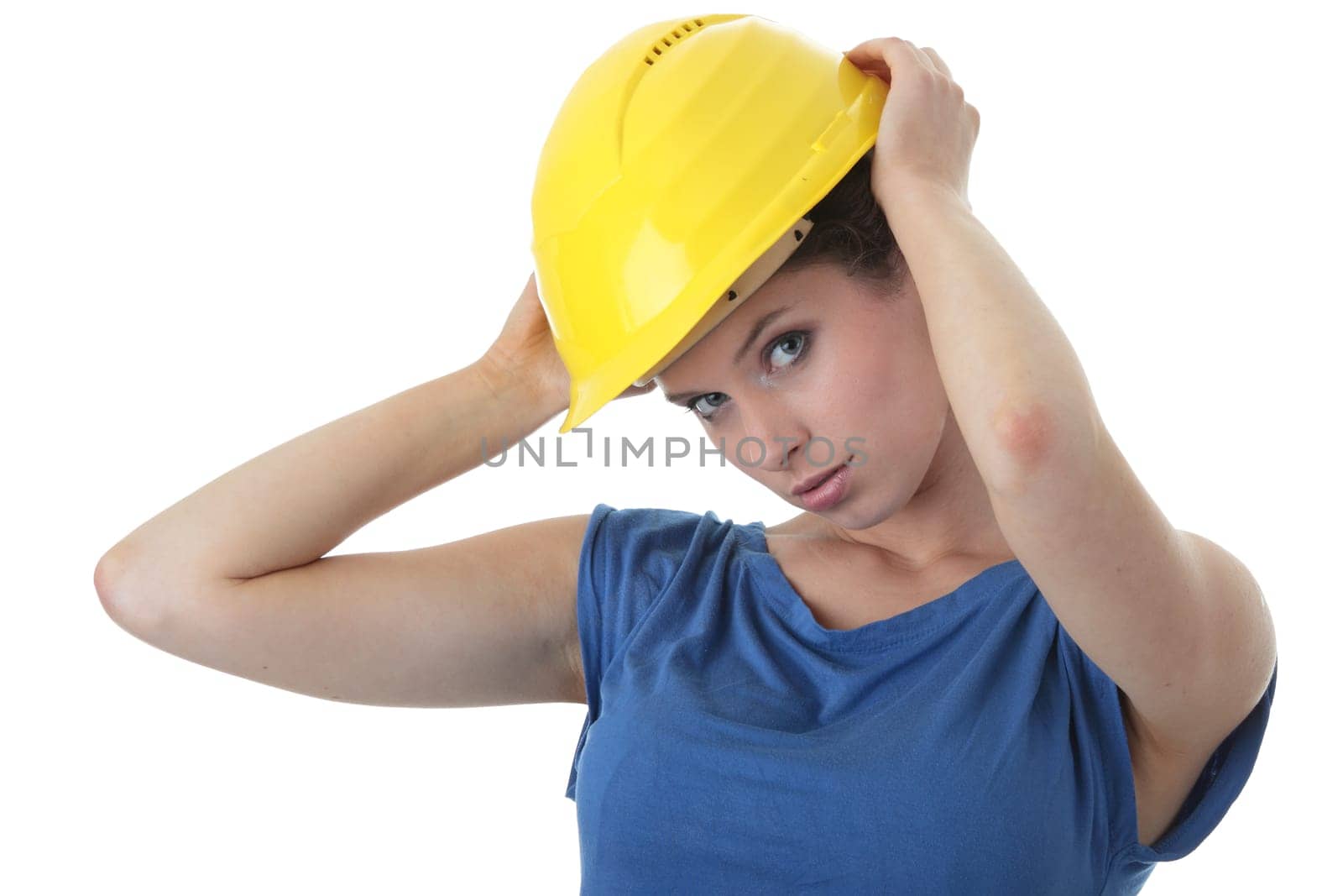 Young female architect or builder wearing a yellow hart hat on a construction site