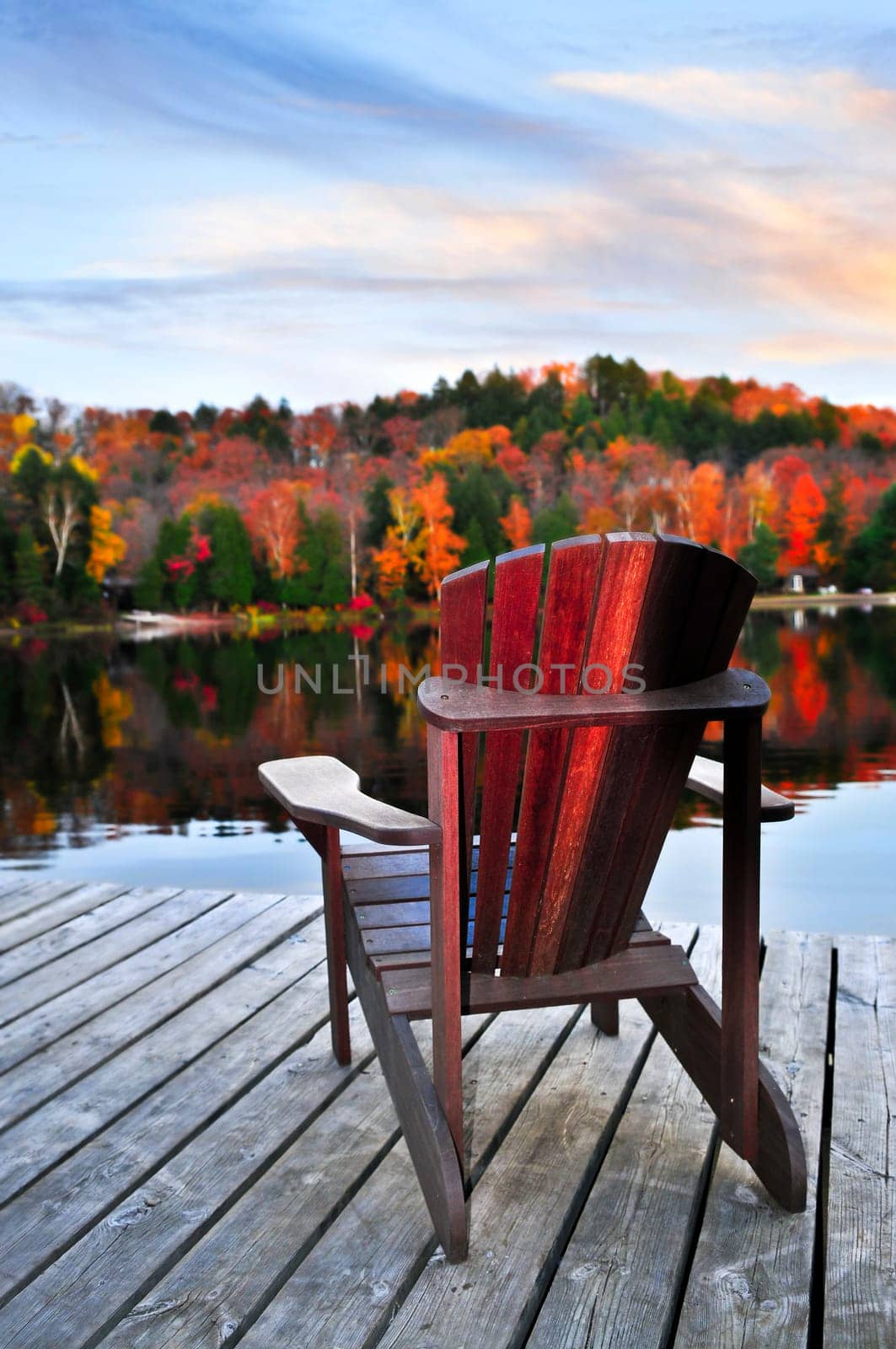 Wooden dock with chair on calm fall lake