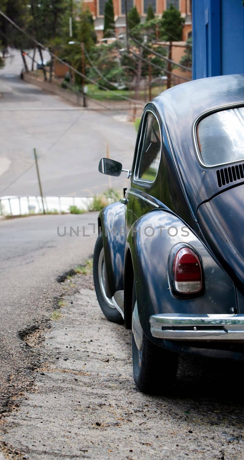 Old black car parked on a steep street