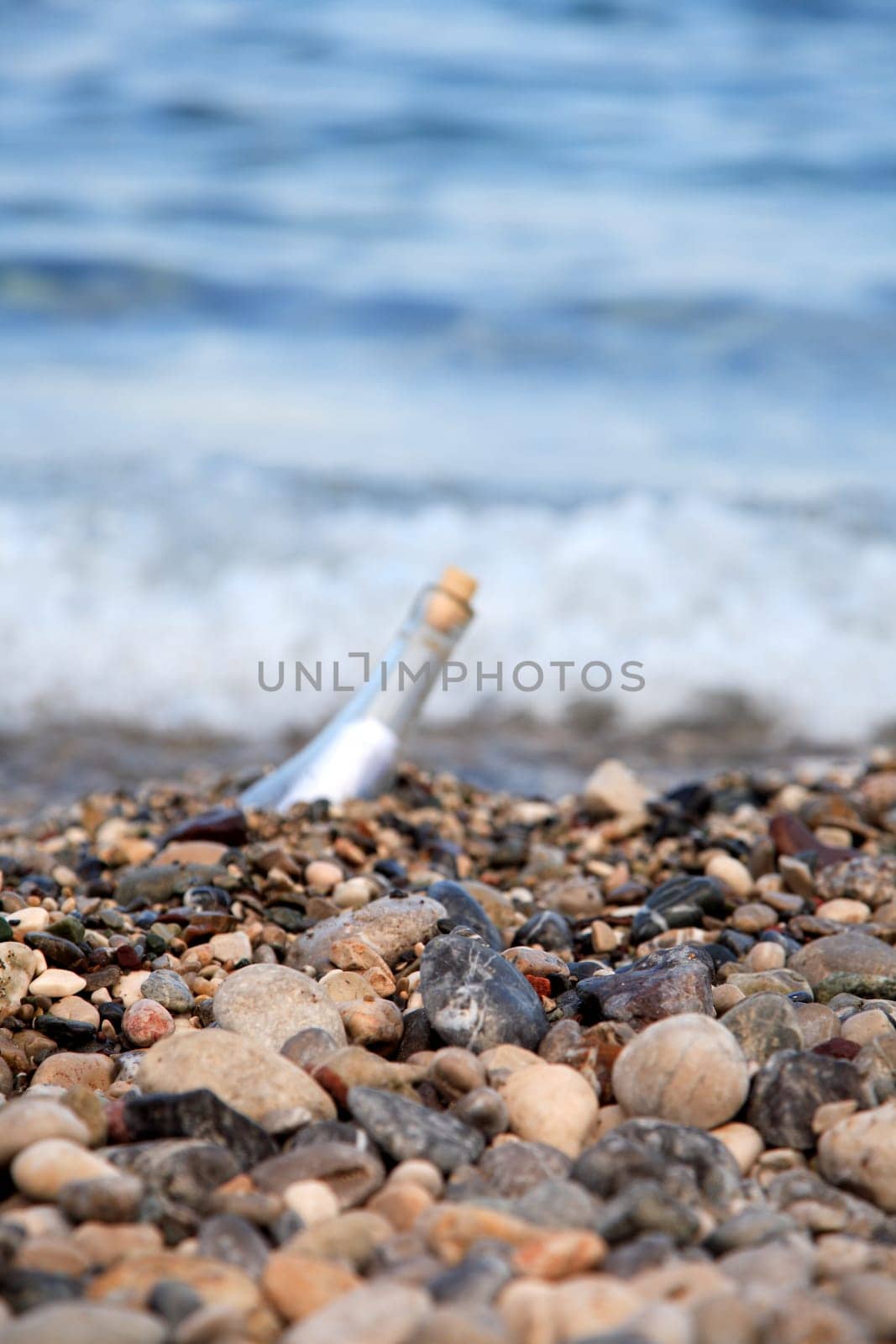 Transparent glass bottle with a note on seacoast