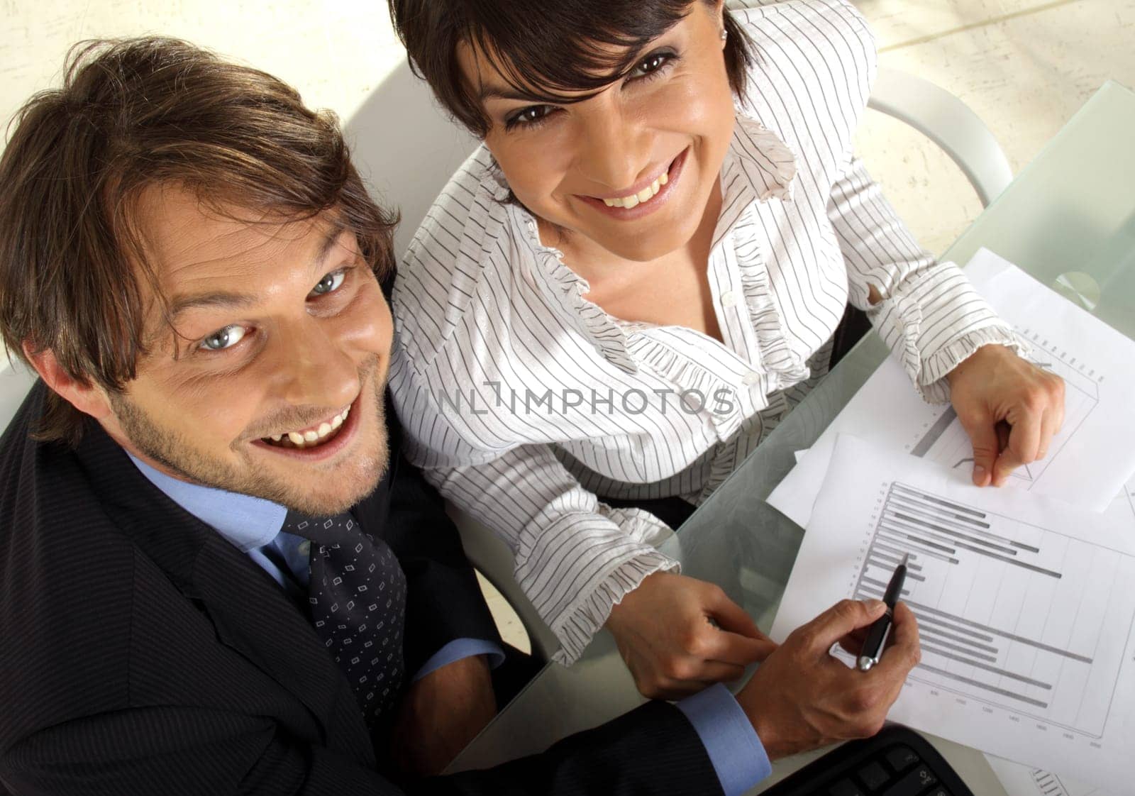 two smiling business people are making an analyses together