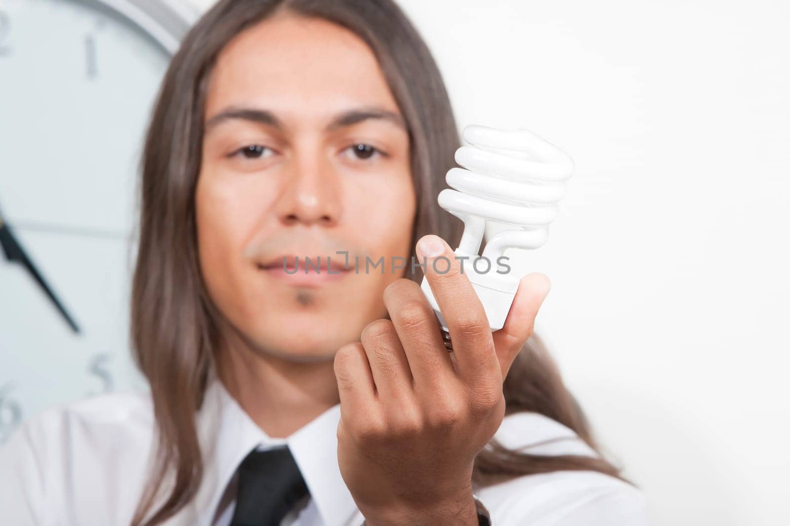 Handsome young man holding energy efficient lightbulb