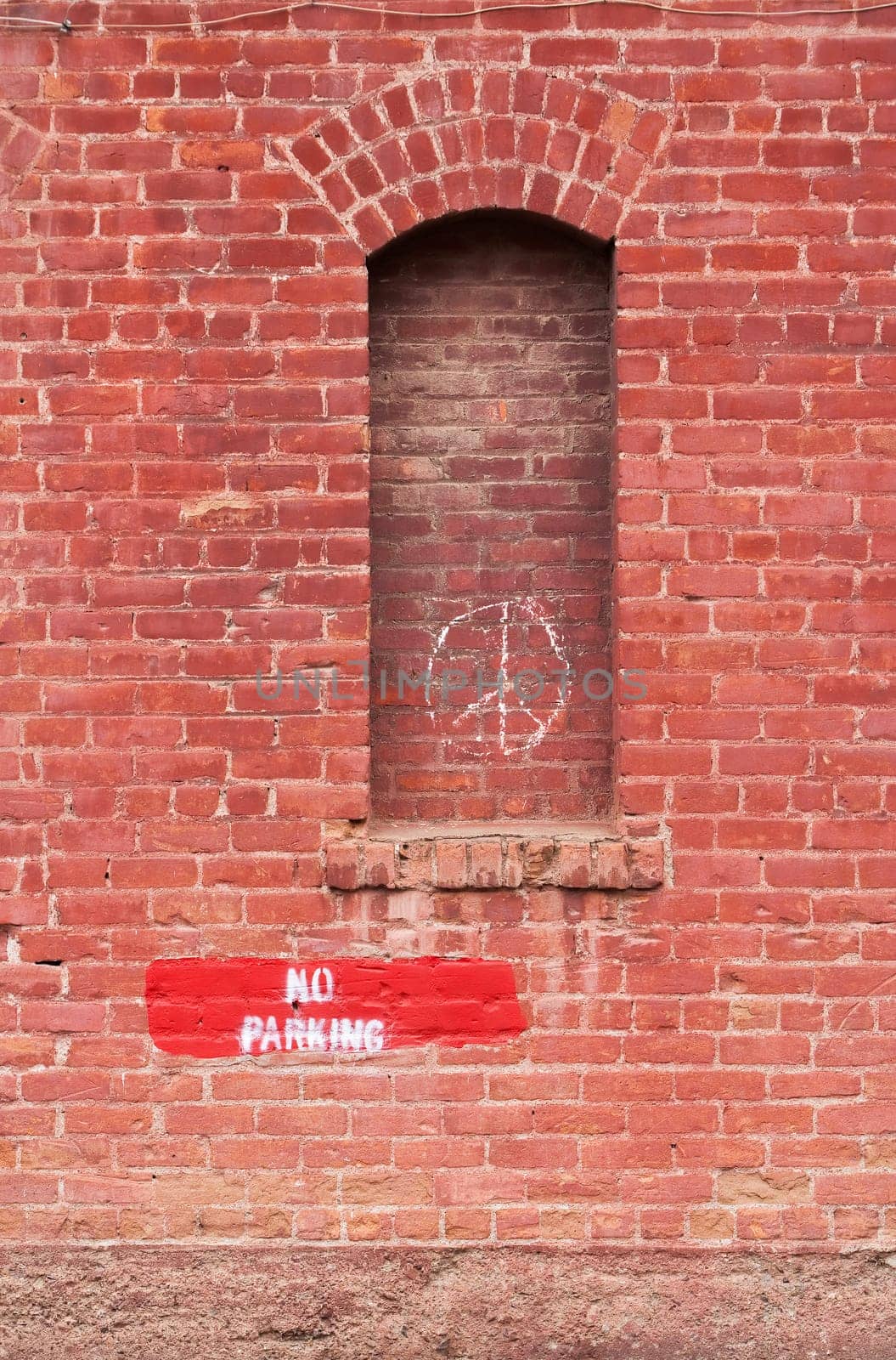 Brick wall with no parking and peace signs