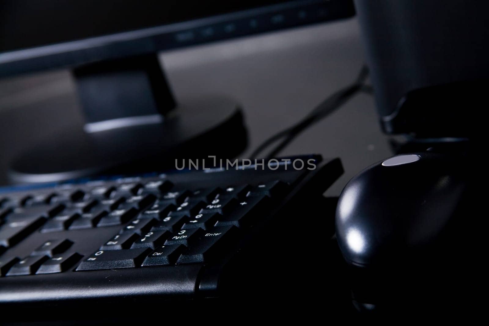 Black desktop computer on desk with mouse, keyboard and monitor