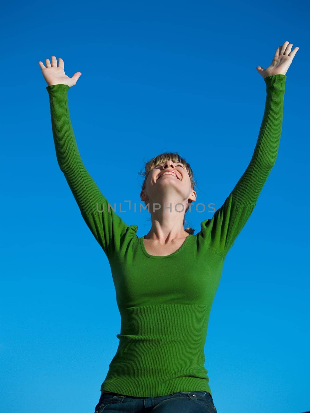 Portrait of the young woman posing on a background of the dark blue sky