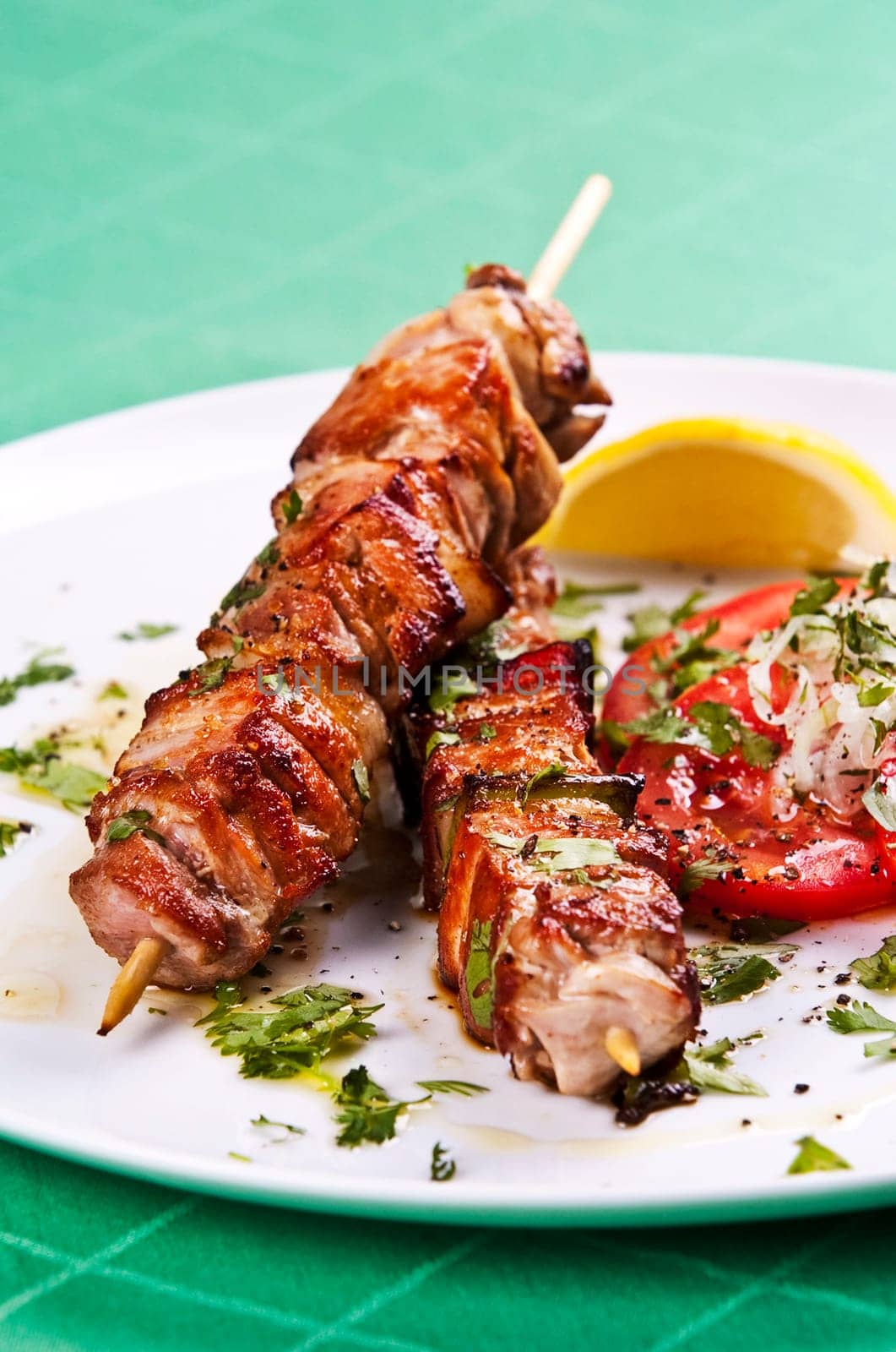 Grilled kebab served with a fresh tomato salad