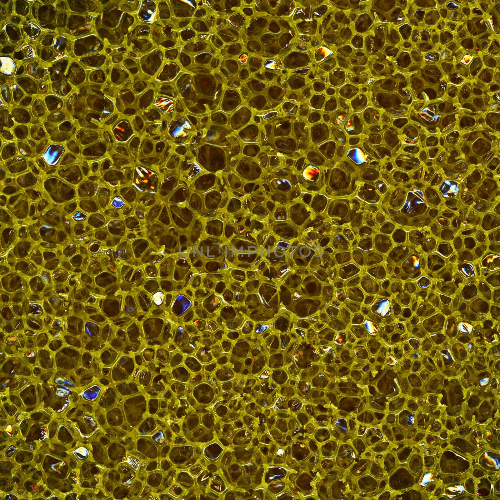 Dark porous sponge made of plastic, close-up