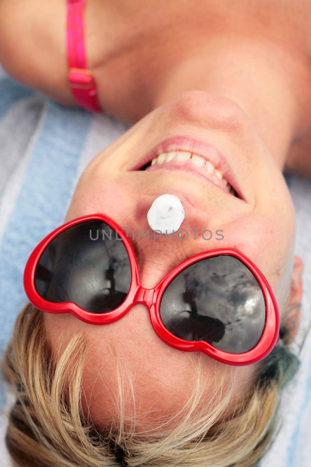 Woman laughing with sunscreen on her nose