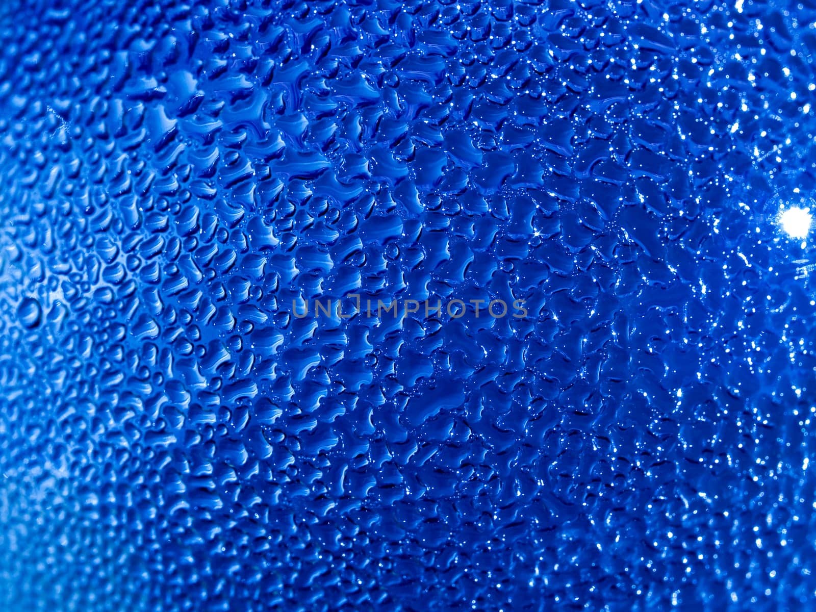 Water droplets formed from condensation inside a blue bottle