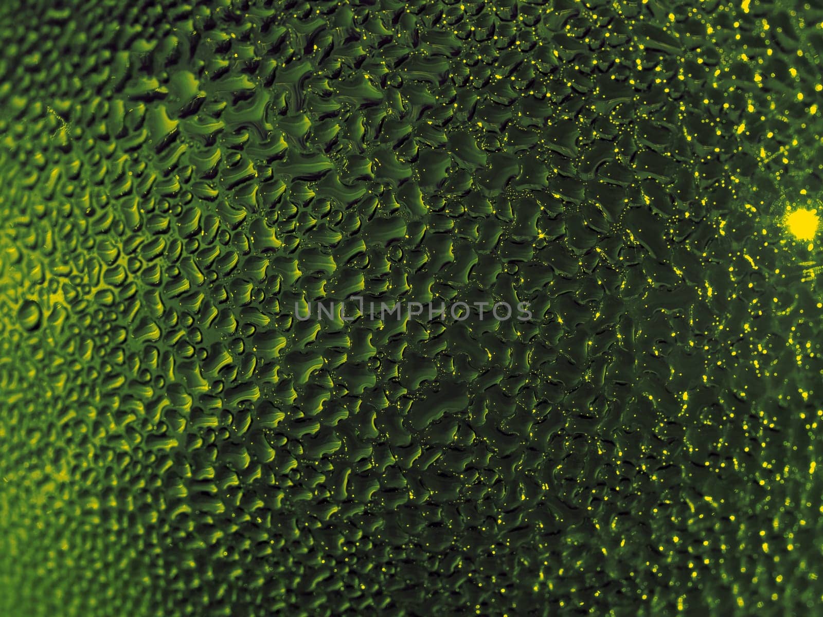 Water droplets formed from condensation inside a dark green bottle