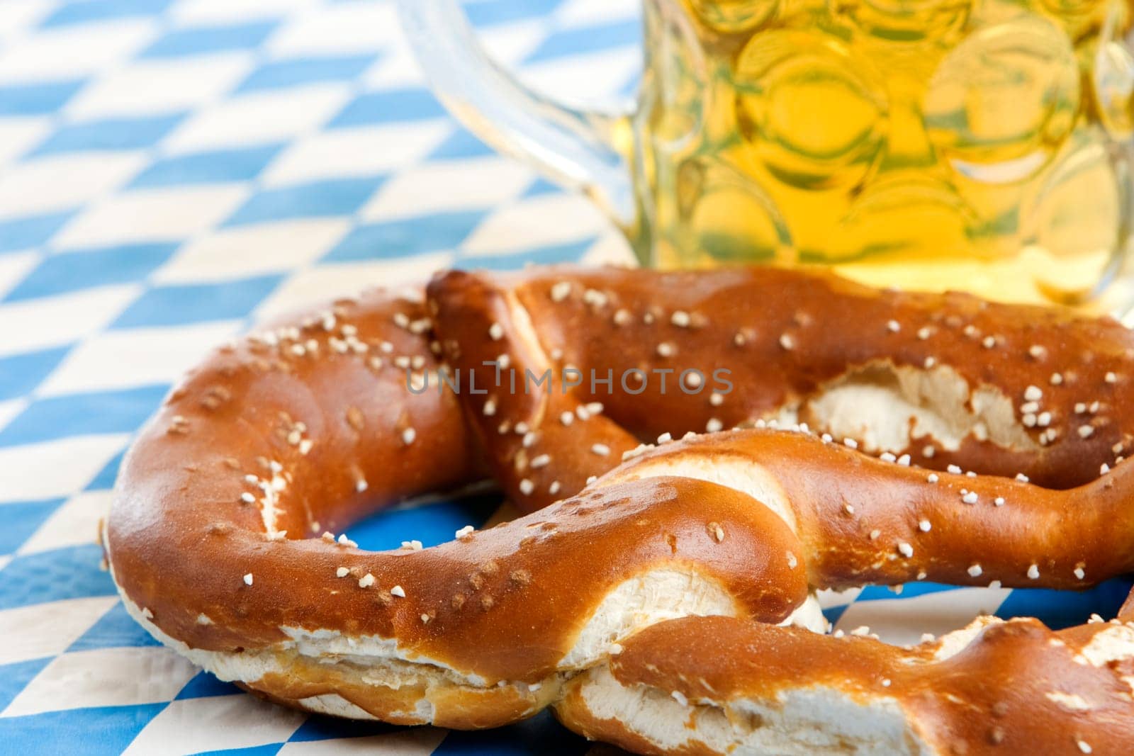 Close-up of one Bavarian Oktoberfest pretzel with beer stein (mug)