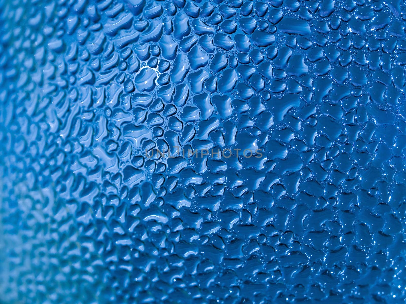Water droplets formed from condensation inside a blue bottle