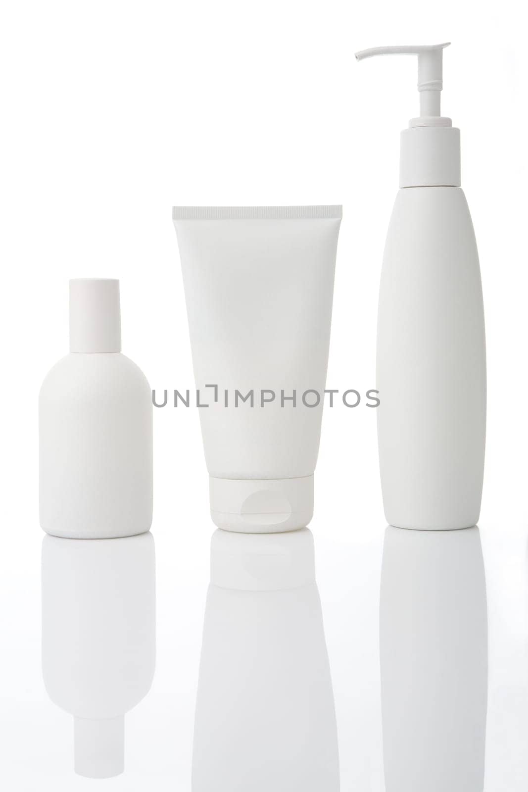 Three white cosmetic bottles stand on a white background