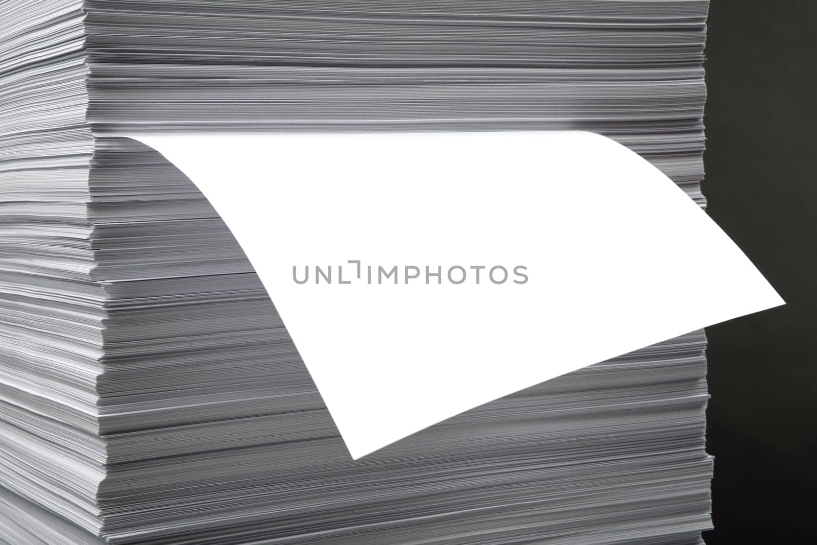 The white pure leaf which is sticking out of a pile of a paper