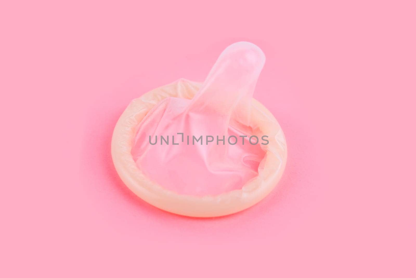 yellow condom on pink background