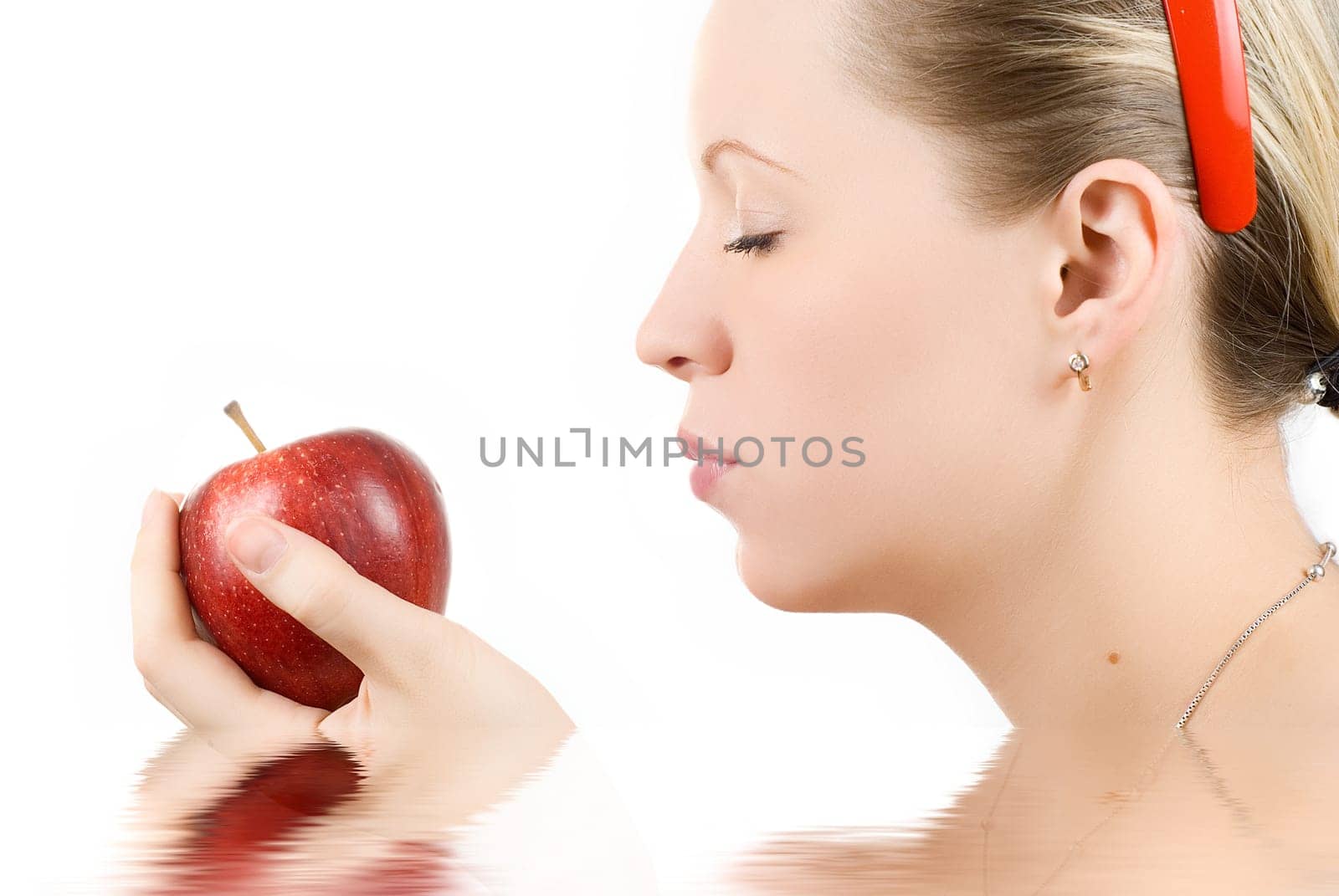 Pretty young woman with apple isolated on white