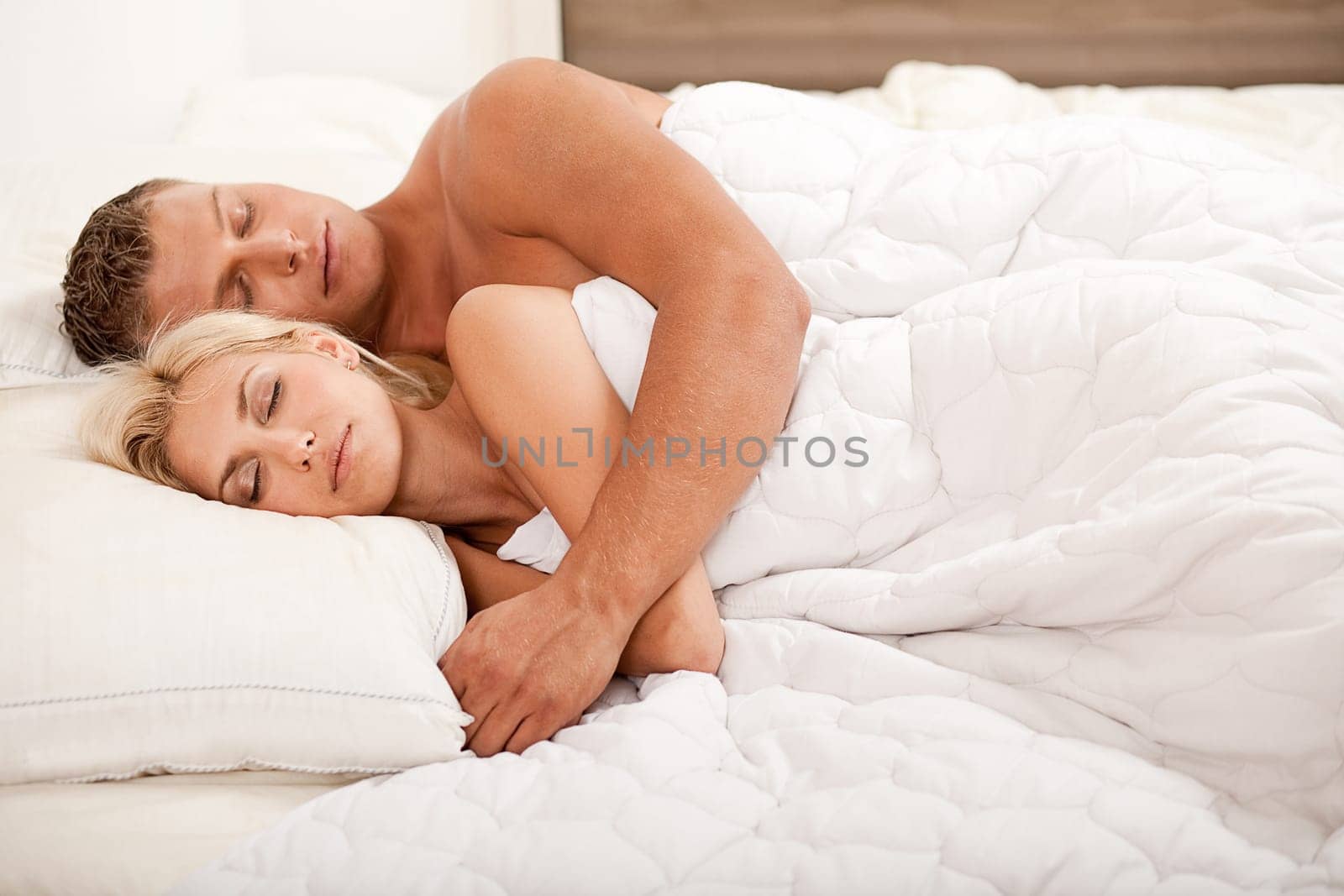 Young couple sleeping and hugging on bed