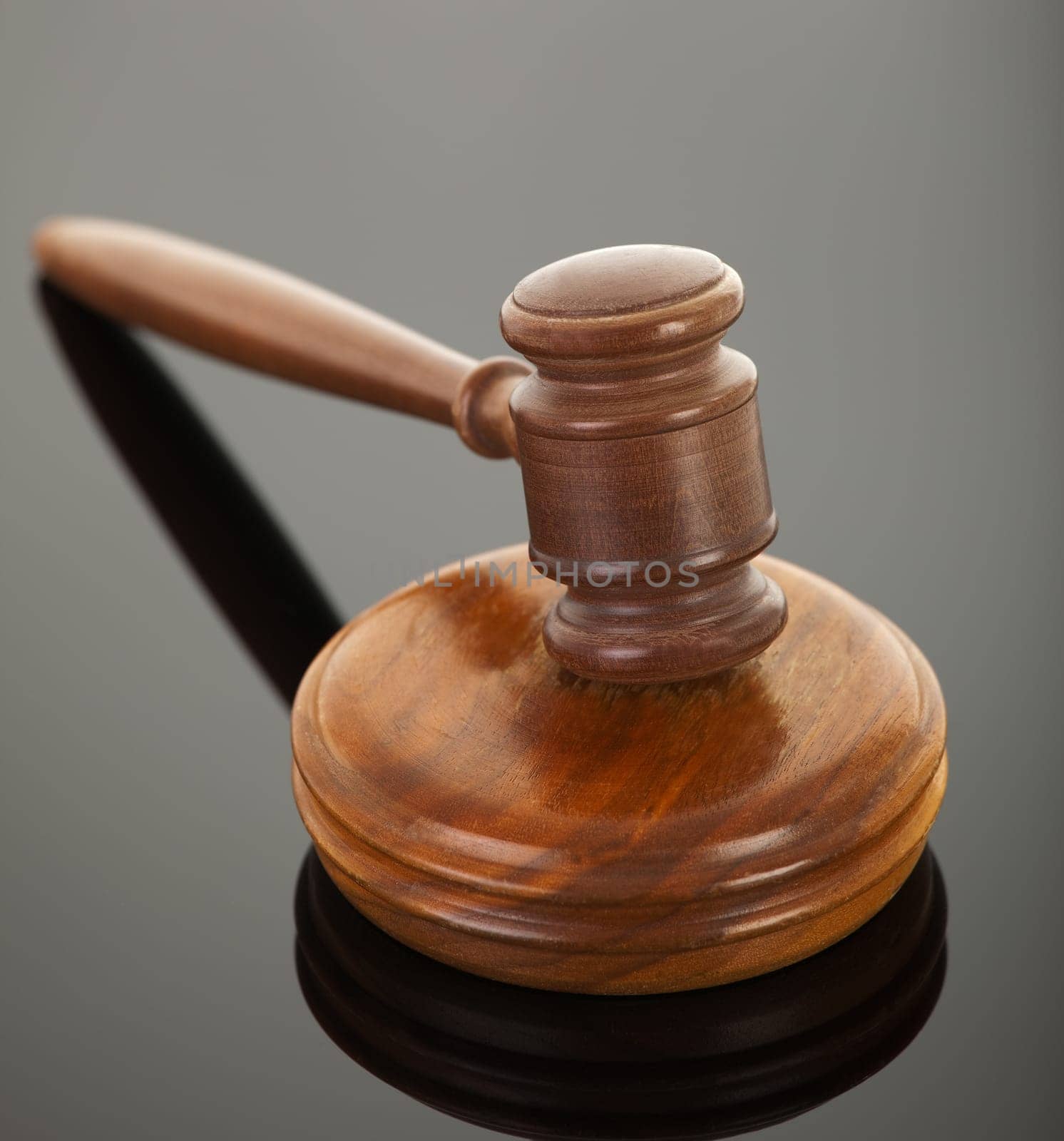 wooden gavel with reflection on black