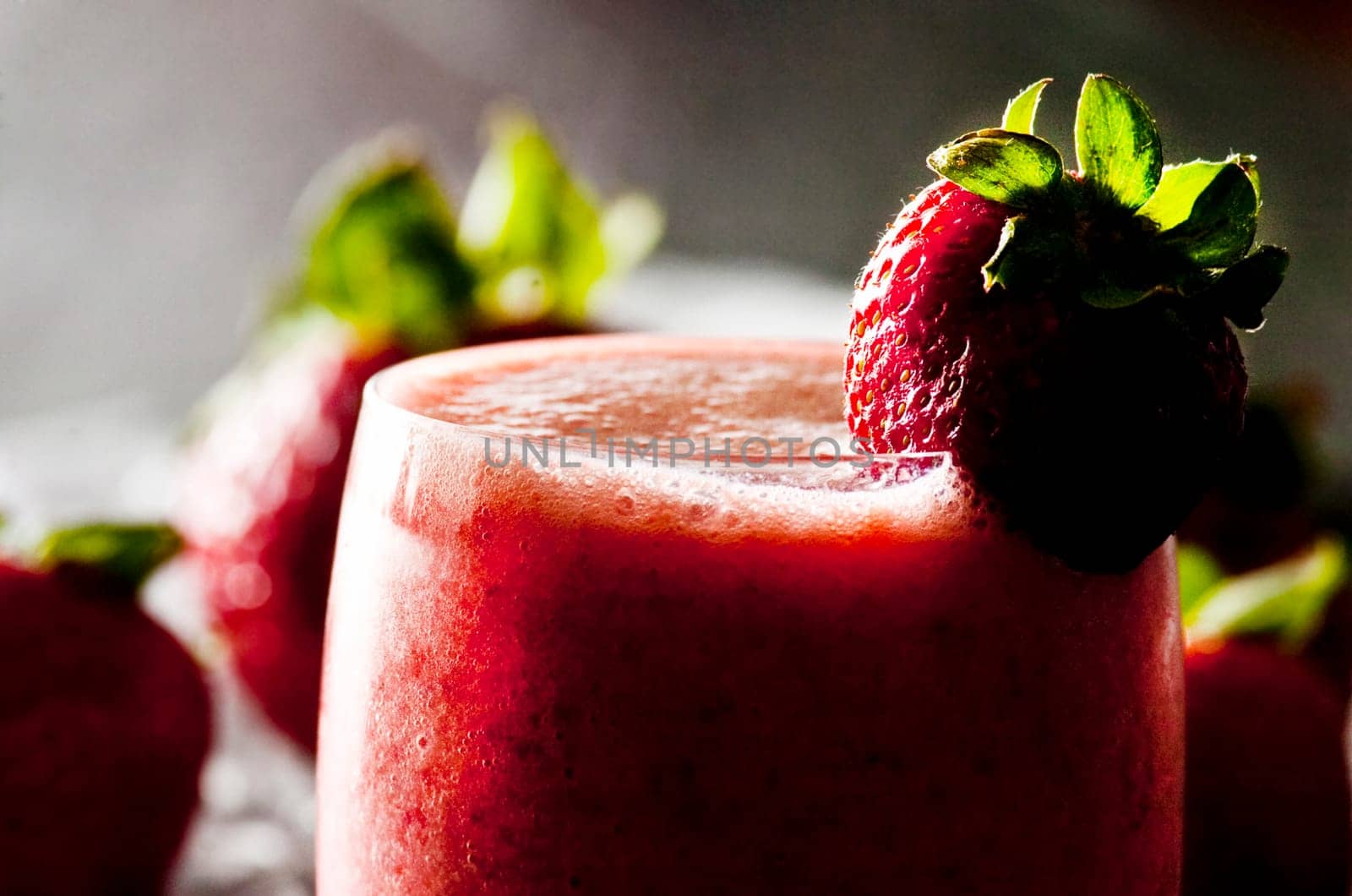 backlit glass of freshly made strawberry smoothie