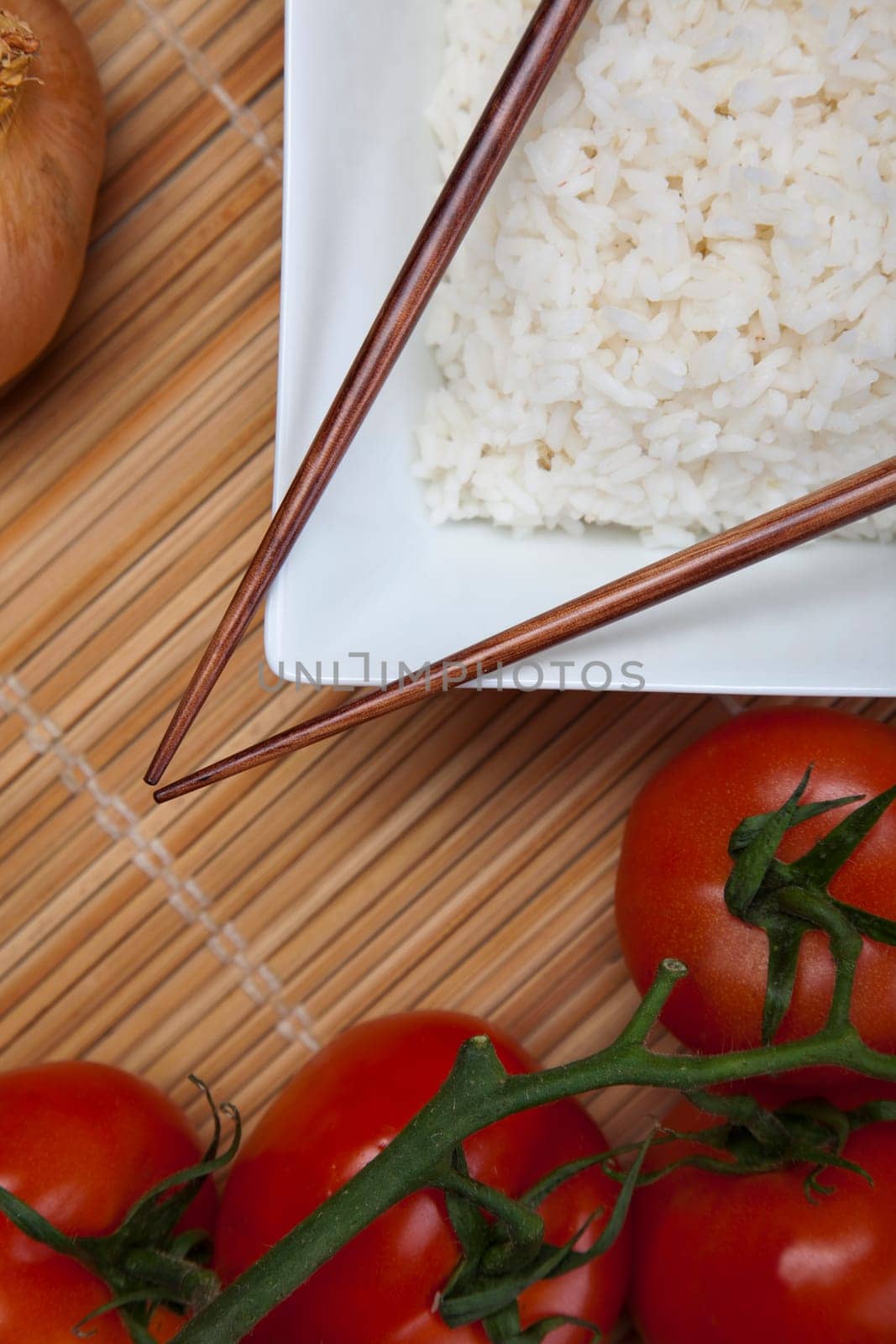 A bowl of perfectly cooked, plain Basmati rice, in an Asian style bowl, with a garnish of Thai Basil