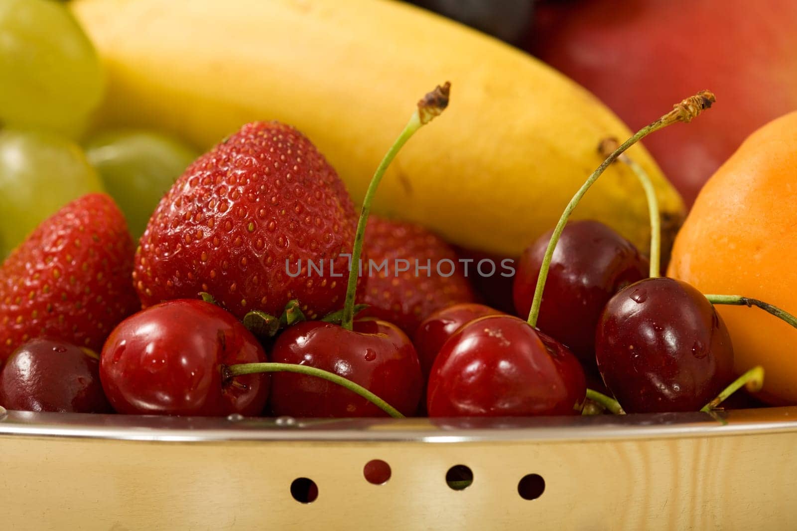 Summer fruits in stainless steel bowl - closeup