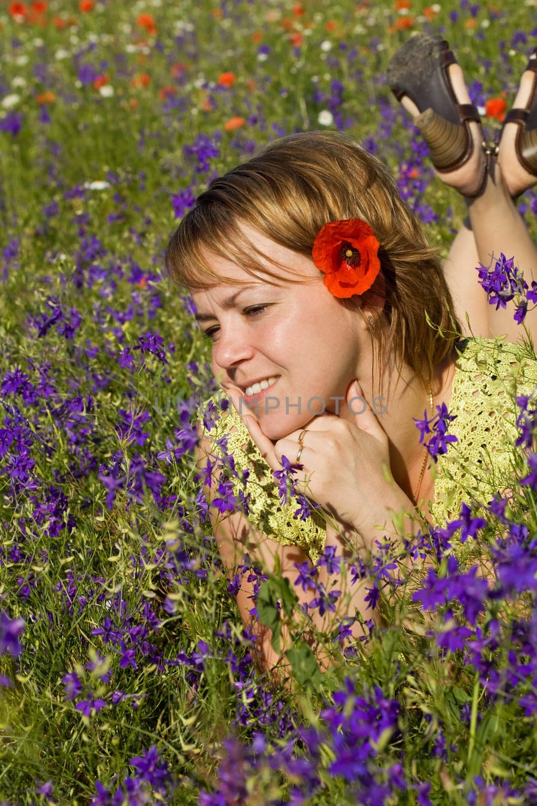 Woman laying among wildflowers outdoors enjoying the sun