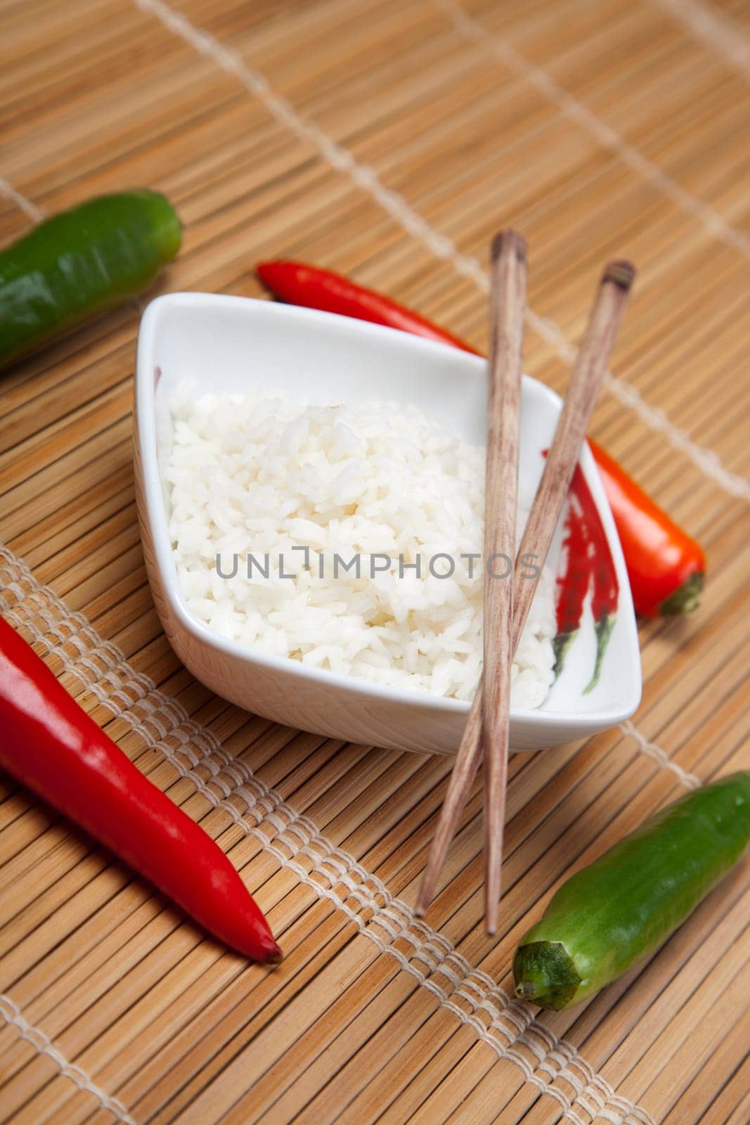 A bowl of perfectly cooked, plain Basmati rice, in an Asian style bowl, with a garnish of Thai Basil