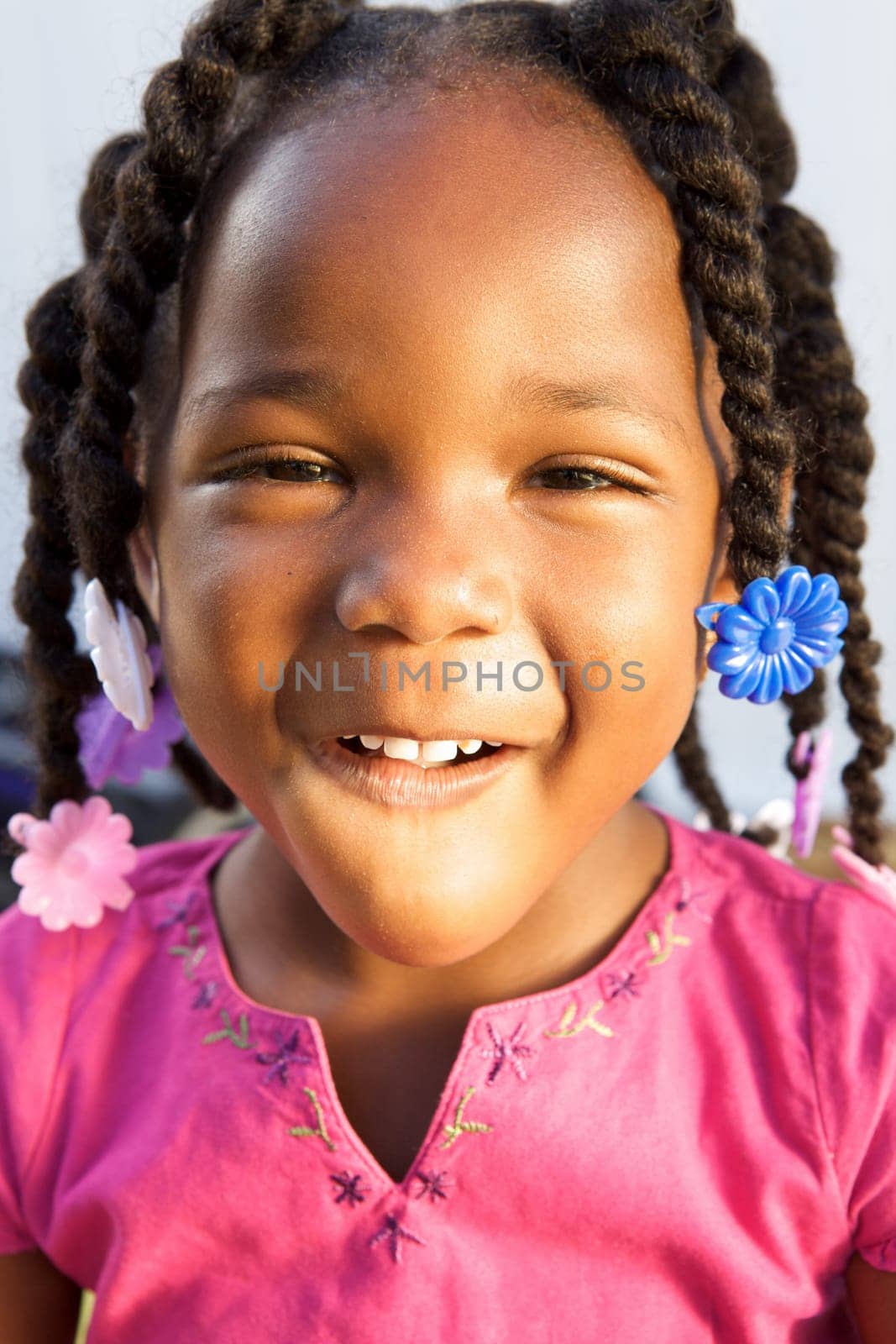 An adorable little african american girl in a pink shirt
